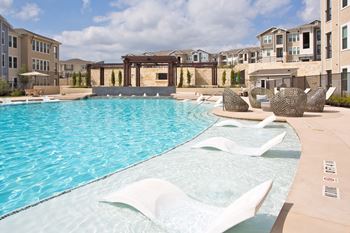 Pool with a white fountain in the middle of it